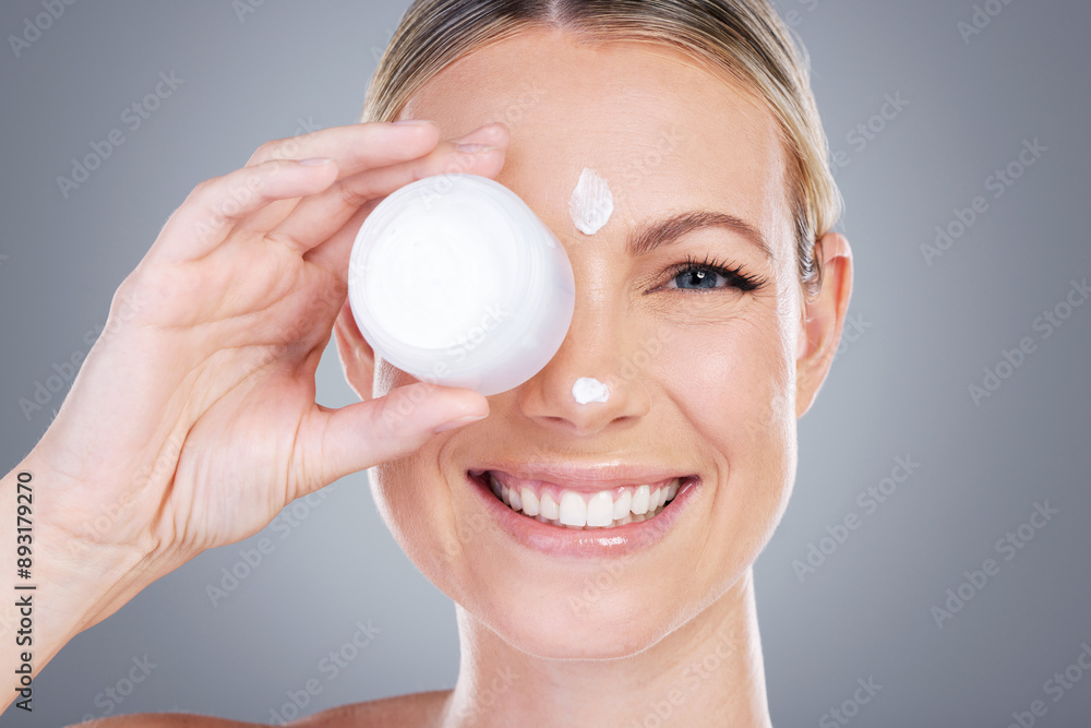 Happy woman, portrait and lotion with container for face cream or skincare moisturizer on a gray studio background. Young female person or model with smile for facial ointment or anti aging cosmetics Happy woman, portrait and lotion with container for face cream or skincare moisturizer on a gray studio background. Young female person or model with smile for facial ointment or anti aging cosmetics