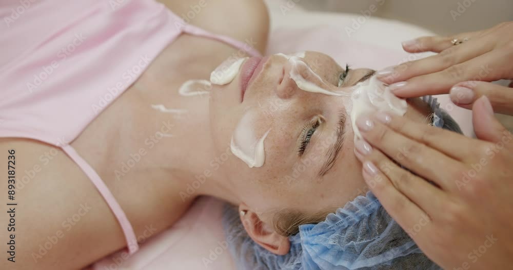 A close-up view of a professional skincare treatment where an expert applies a facial mask on a woman's face, promoting relaxation and skin health. Professional Skincare Treatment, Facial Mask A close-up view of a professional skincare treatment where an expert applies a facial mask on a woman's face, promoting relaxation and skin health. Professional Skincare Treatment, Facial Mask