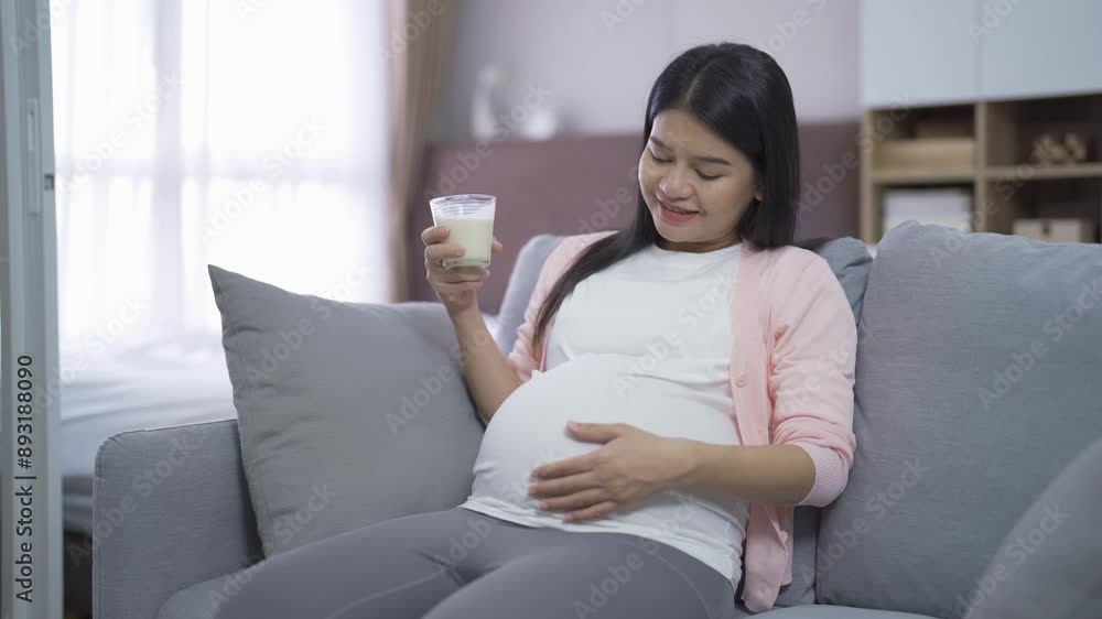 A portrait of happy Asian pregnant woman drinking milk for calcium in bedroom at home. Having a baby. Family people lifestyle. Mom love. A portrait of happy Asian pregnant woman drinking milk for calcium in bedroom at home. Having a baby. Family people lifestyle. Mom love.