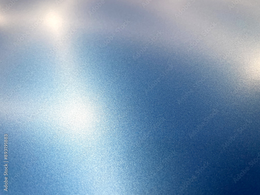A specialist in the process of work glues the car with an blue vinyl film. Car wrapping specialists cover the car with vinyl sheet or film. Car detailing concept. A specialist in the process of work glues the car with an blue vinyl film. Car wrapping specialists cover the car with vinyl sheet or film. Car detailing concept.