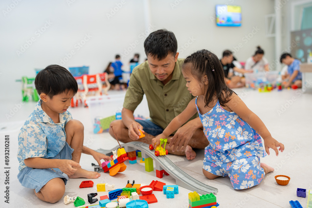 Dad play colorful toy block building with child boy and girl indoor playground Dad play colorful toy block building with child boy and girl indoor playground
