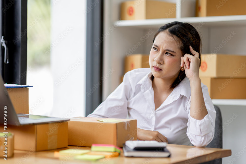 Asian woman think hard serious working of sme laptop computer at home selling online start up small business owner, e-commerce ideas concept. Asian woman think hard serious working of sme laptop computer at home selling online start up small business owner, e-commerce ideas concept.