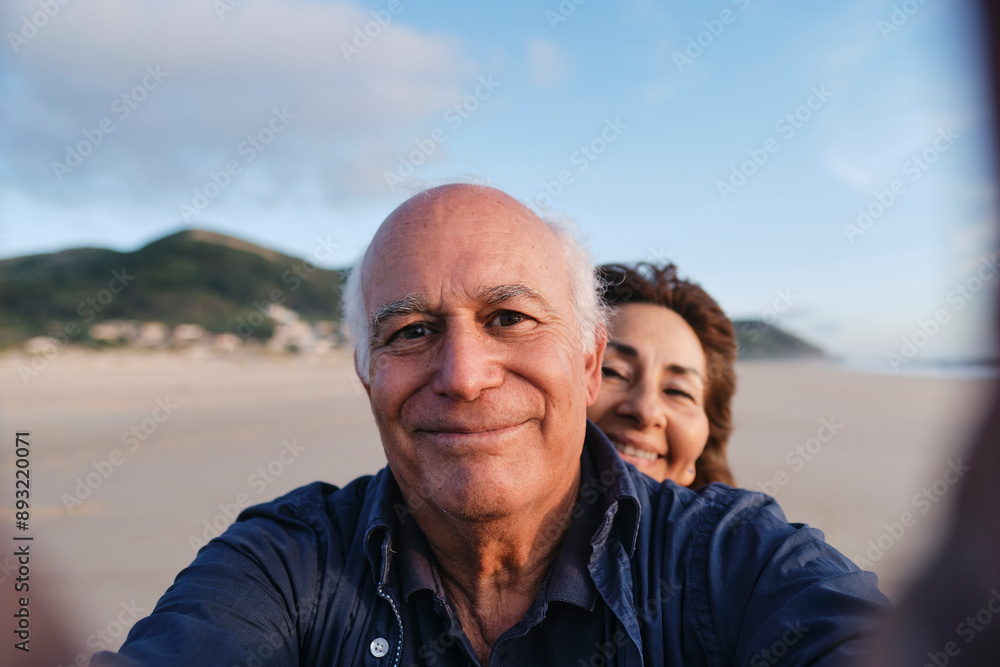 Smiling senior man taking selfie with woman at beach Smiling senior man taking selfie with woman at beach