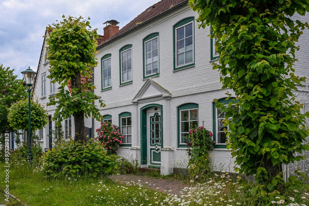Germany, Schleswig-Holstein, Arnis, Trees and blooming flowers outside two storey building Germany, Schleswig-Holstein, Arnis, Trees and blooming flowers outside two storey building
