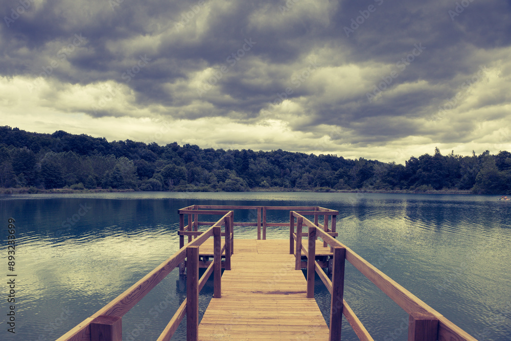 Naklejka premium ponton de pêche sur le lac de Virieu le grand dans l'ain un jour d'orage