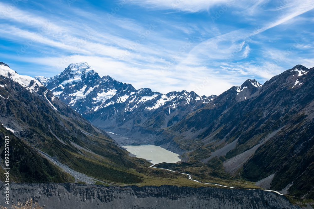 Fototapeta premium An expansive view of a mountain range with snow-capped peaks and a clear blue sky, showcasing the beauty and vastness of nature.