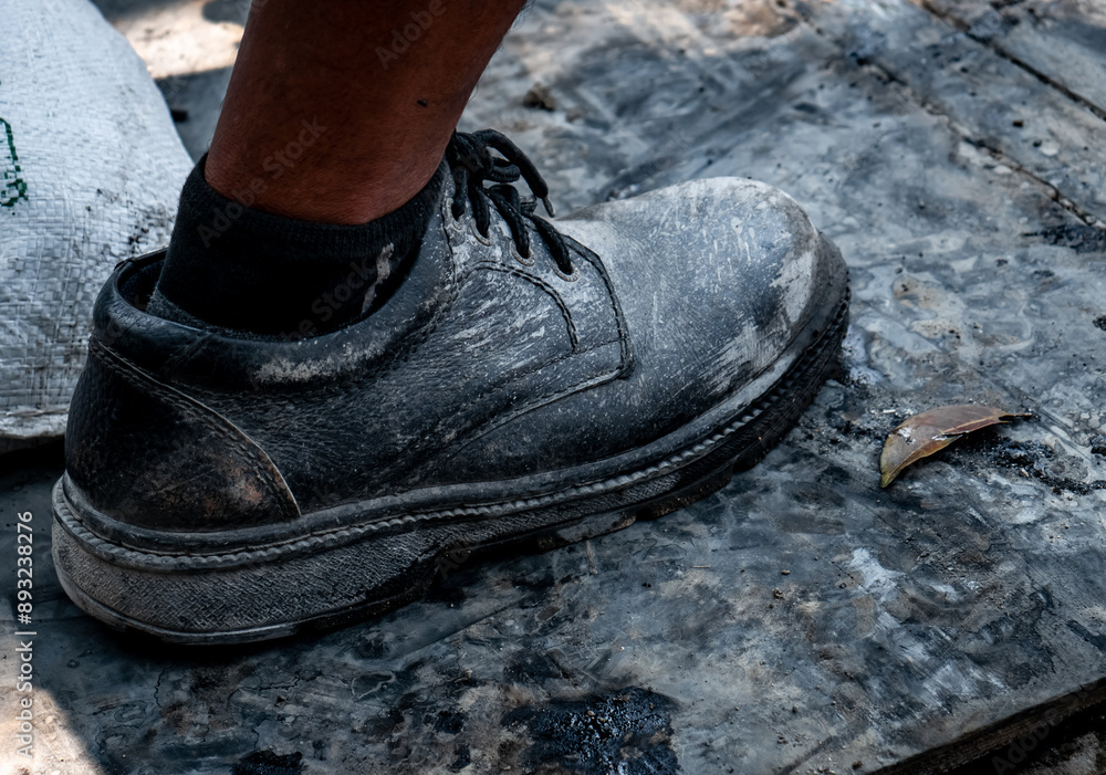 worn black shoes made of leather and strong material covered with leather are used for field construction work worn black shoes made of leather and strong material covered with leather are used for field construction work