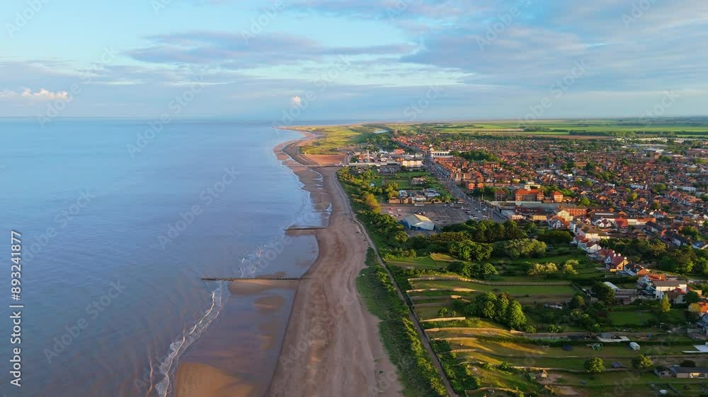 Sweeping aerial views of the seaside town of Skegness on the Lincolnshire Coast of England. Open beaches with pier and tourist attractions. Busy summer holiday destination. Sunset scene Sweeping aerial views of the seaside town of Skegness on the Lincolnshire Coast of England. Open beaches with pier and tourist attractions. Busy summer holiday destination. Sunset scene