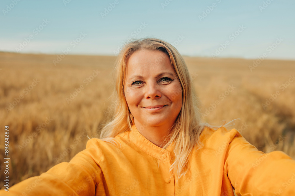 Smiling blond hair woman in yellow shirt on wheat field Smiling blond hair woman in yellow shirt on wheat field