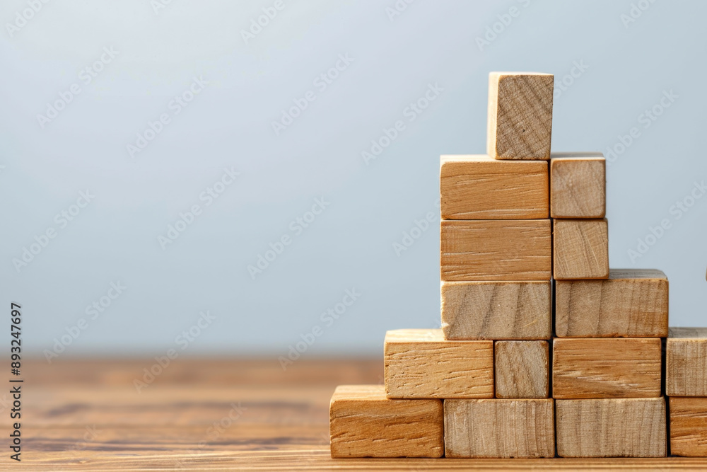 Stacked blocks with one block being carefully placed, risk management concept, building stability Stacked blocks with one block being carefully placed, risk management concept, building stability