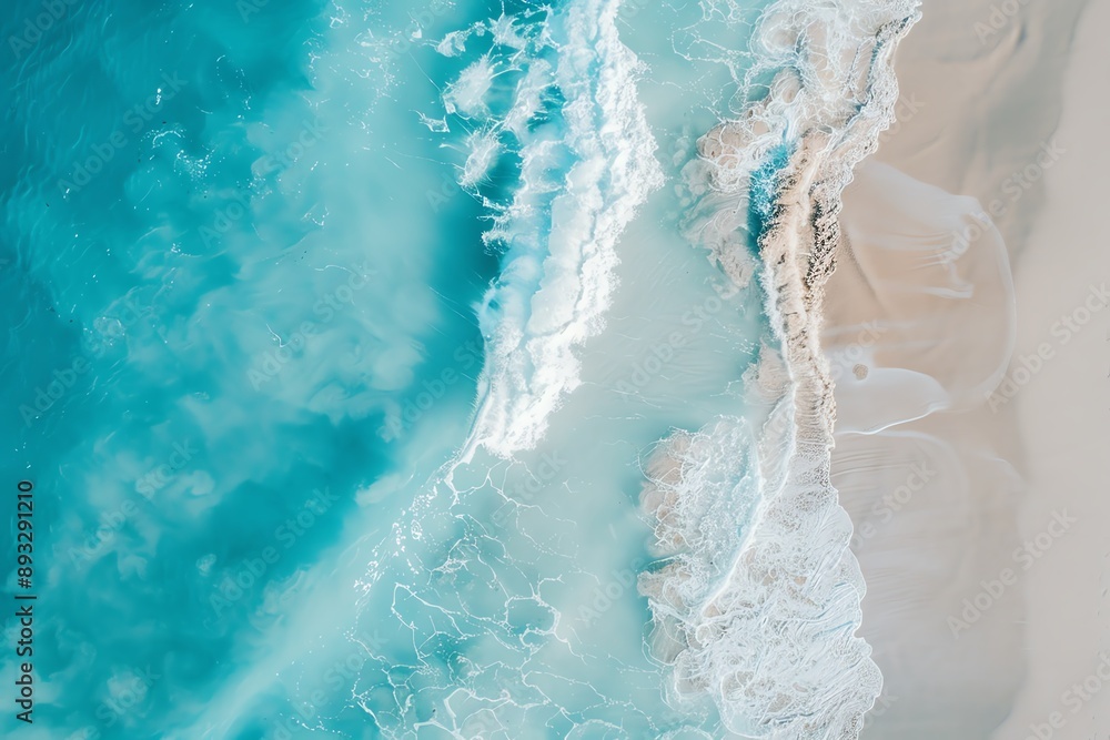 Naklejka premium Aerial view of turquoise ocean waves crashing on white sandy beach.