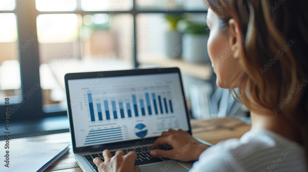 Businesswoman Analyzing Financial Data on Laptop
