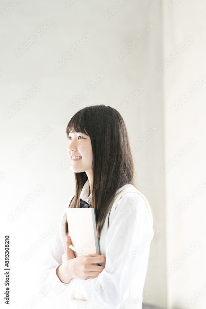 ノートとシャープペンシルを持っている制服姿の女子学生 ノートとシャープペンシルを持っている制服姿の女子学生