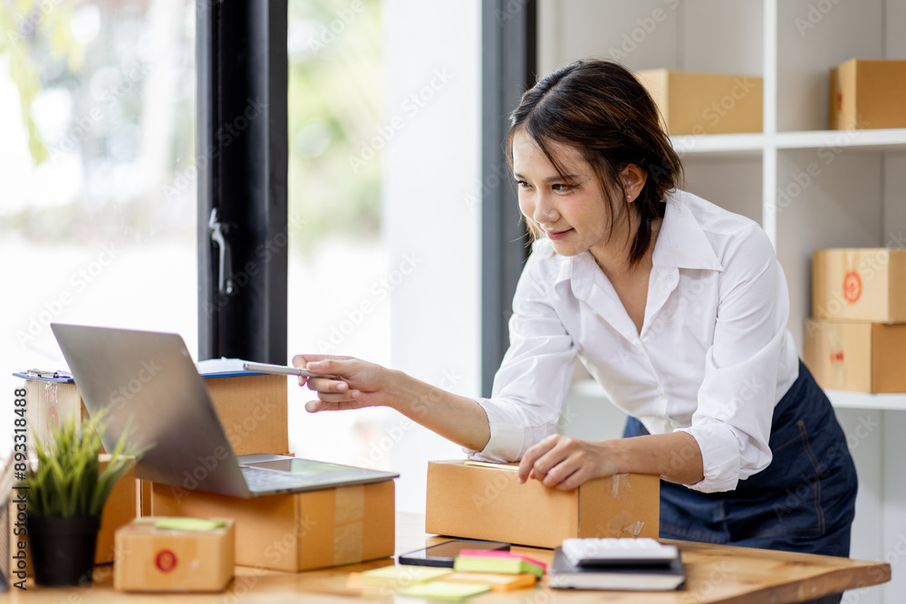 SME concept. Young asian female ecommerce business owner prepares package box for customer and delivery check balance. SME small business entrepreneur SME or freelance SME concept. Young asian female ecommerce business owner prepares package box for customer and delivery check balance. SME small business entrepreneur SME or freelance