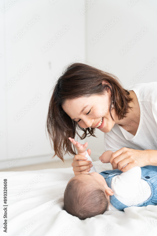 赤ちゃんをあやしながら笑っている母親 赤ちゃんをあやしながら笑っている母親