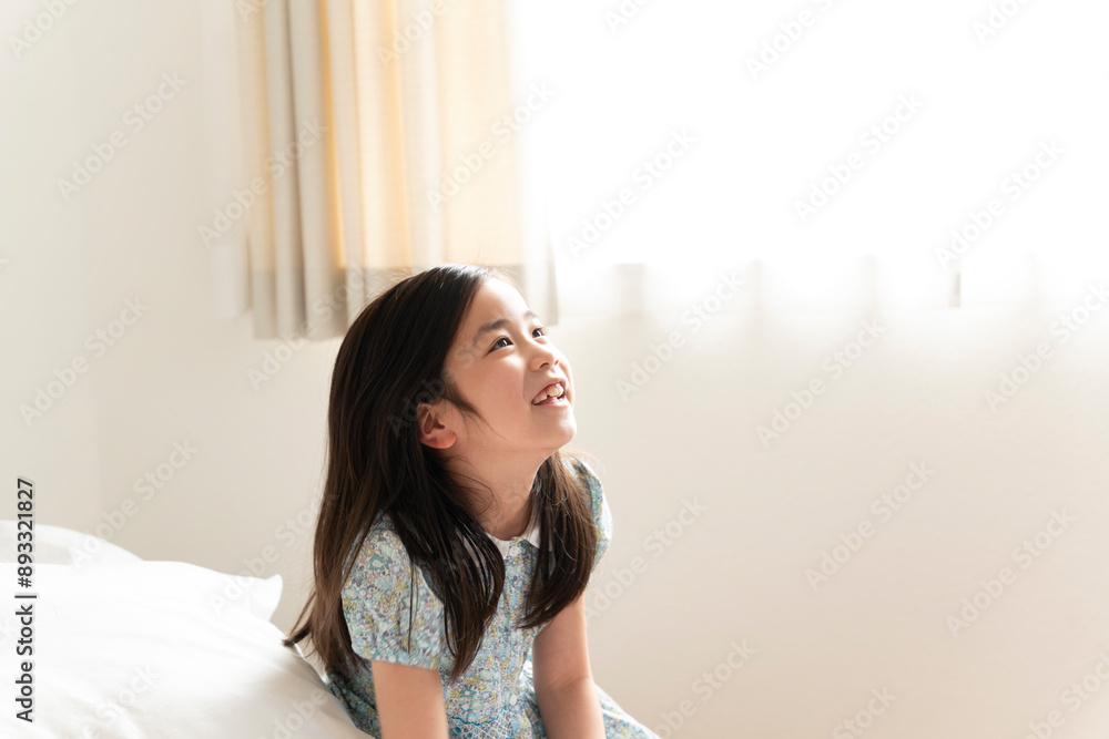 部屋で上を見上げて笑っている女の子