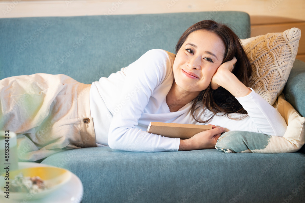 ソファに座って本を持っている女性 ソファに座って本を持っている女性