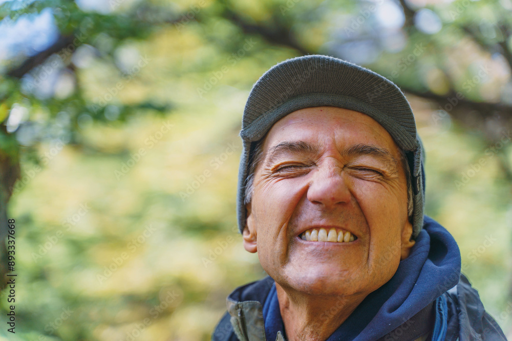 A man with a hat and a blue hoodie is smiling. He has a beard and is wearing a hat A man with a hat and a blue hoodie is smiling. He has a beard and is wearing a hat