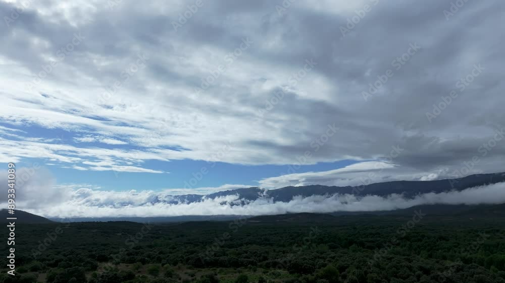 I fly with a drone in the Tietar-Avila valley and with a turn of the camera we see a cloud in a line of several km on the slope of the mountains and a sky covered in clouds but there is a blue part I fly with a drone in the Tietar-Avila valley and with a turn of the camera we see a cloud in a line of several km on the slope of the mountains and a sky covered in clouds but there is a blue part