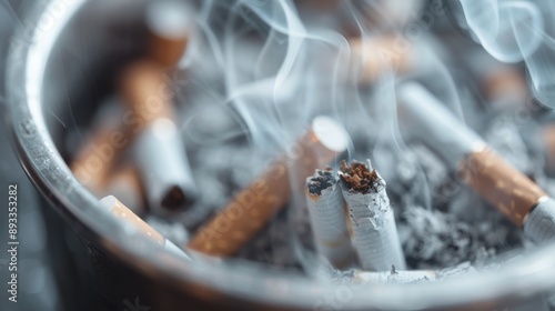 Ashtray densely filled with cigarette butts emitting smoke, symbolic of habitual smoking, addiction, and the inevitable accumulation of waste as a result.