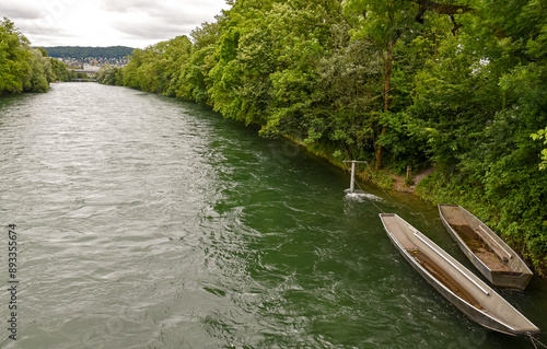 Obraz na płótnie Scenic Limmat Riverbank in Zurich: Lush Greenery and Traditional Boats w salonie