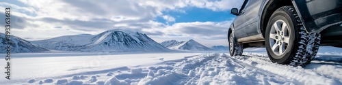 A car is parked on a snowy road in front of a mountain. The car is covered in snow and the road is covered in snow as well. The scene is peaceful and serene