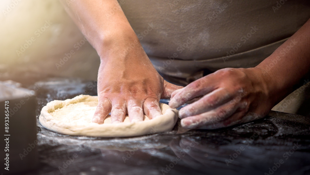 An Italian chef making pizza dough uses his hands to knead and roll it out. An Italian chef making pizza dough uses his hands to knead and roll it out.