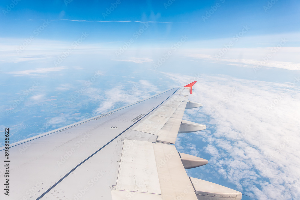 View from the airplane window at a beautiful cloudy sky and the airplane wing View from the airplane window at a beautiful cloudy sky and the airplane wing