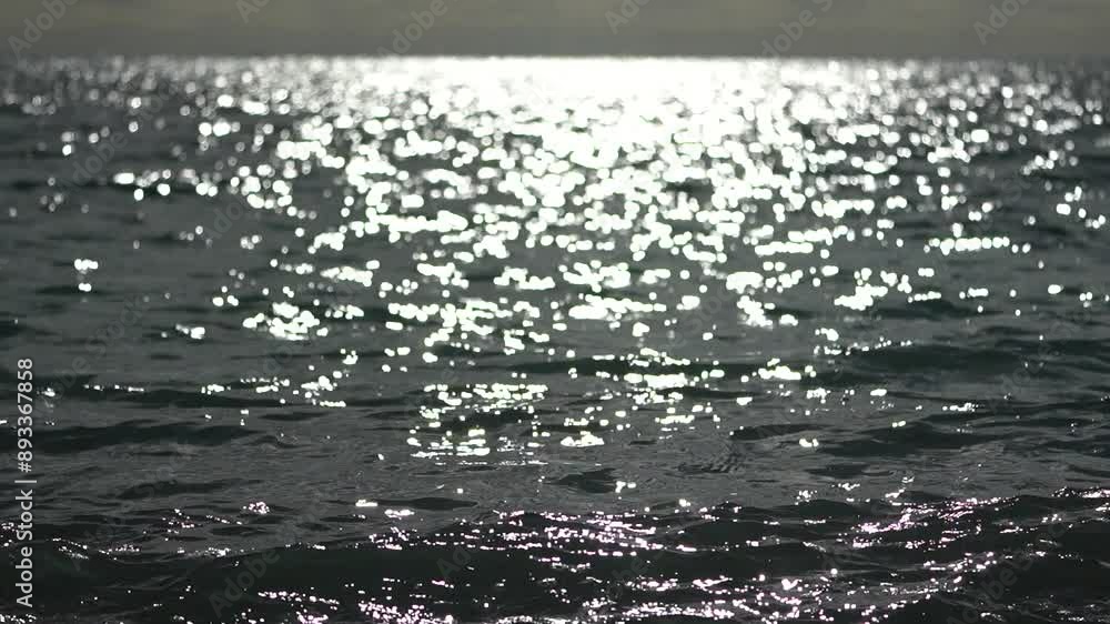 Abstract sea summer ocean sunset nature background. Small waves on golden water surface in motion blur with golden bokeh lights from sun. Holiday, vacation and recreation. Weather and climate change