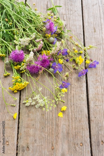 Colorful bouquet of meadow flowers on chalkboard background with empty space. Summer solstice bouquet. Top view, shallow depth of field.