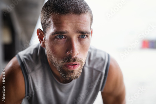 Fototapeta Naklejka Na Ścianę i Meble -  Rest, breathing and runner man with fitness break outdoor from workout, sport and training. Tired, determination and wellness of athlete with closeup and exercise in the city with breathe recovery