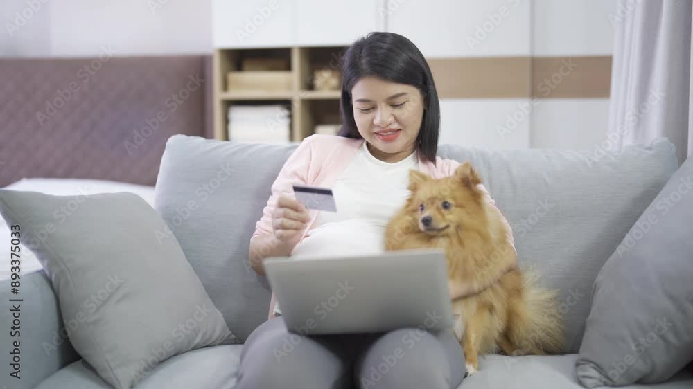 A portrait of happy Asian pregnant woman with domestic dog pet animal in bedroom at home. Having a baby. Family people lifestyle. Mom love. A portrait of happy Asian pregnant woman with domestic dog pet animal in bedroom at home. Having a baby. Family people lifestyle. Mom love.