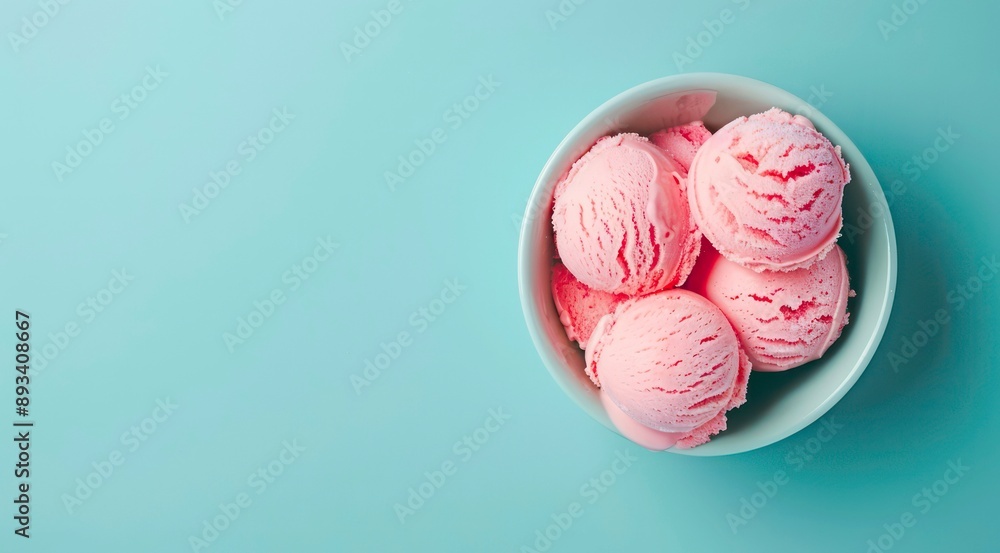 Bowl of pink ice cream scoops on pastel blue background, top view. Bowl of pink ice cream scoops on pastel blue background, top view.