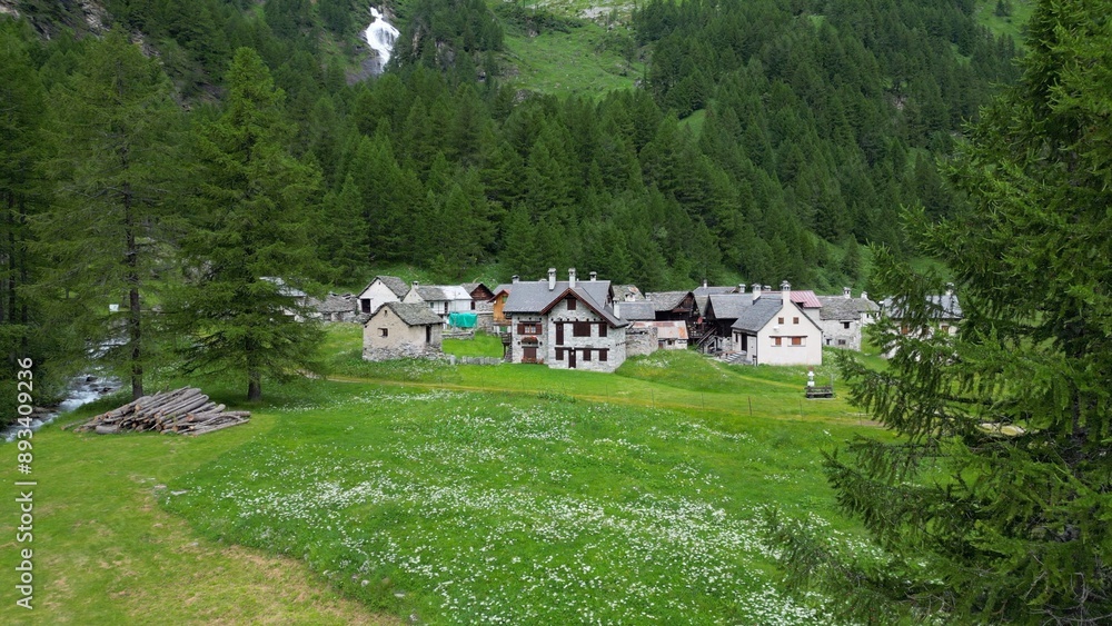 enchanted mountain village in summer with meadow of flowers seen from the drone -increase in tourism in mountain places to visit the ancient villages and go for walks in Alpe Devero,Ossola Apls Italy