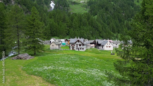 Obraz na płótnie enchanted mountain village in summer with meadow of flowers seen from the drone -increase in tourism in mountain places to visit the ancient villages and go for walks in Alpe Devero,Ossola Apls Italy w salonie