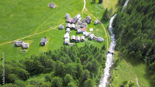Obraz na płótnie enchanted mountain village in summer with meadow of flowers seen from the drone -increase in tourism in mountain places to visit the ancient villages and go for walks in Alpe Devero,Ossola Apls Italy w salonie