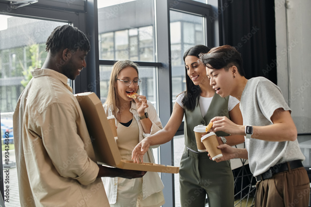 Obraz premium Four colleagues take a break from their work to enjoy pizza and coffee.