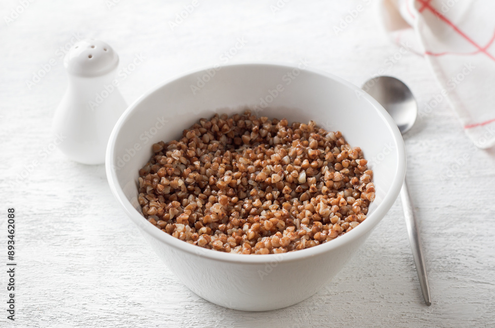 Bowl with boiled buckwheat on a white background. healthy homemade food Bowl with boiled buckwheat on a white background. healthy homemade food