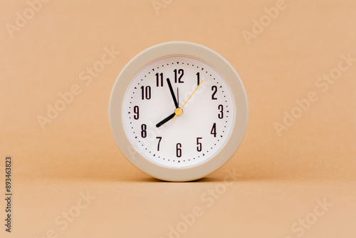 Alarm clock photography in a light brown background studio The concept of time and living and working