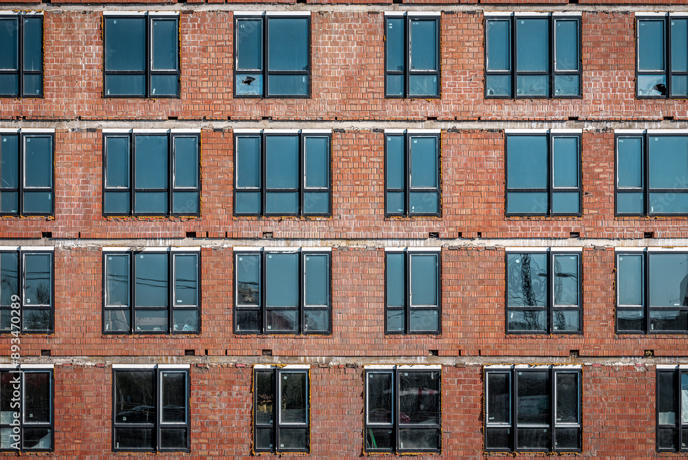 Brick wall of modern skyscraper building under construction, instaled windows texture Brick wall of modern skyscraper building under construction, instaled windows texture