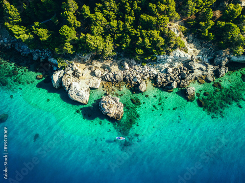 Aerial view of the pristine coastline of Mimice, Croatia, featuring turquoise waters, rocky shoreline, and lush greenery.