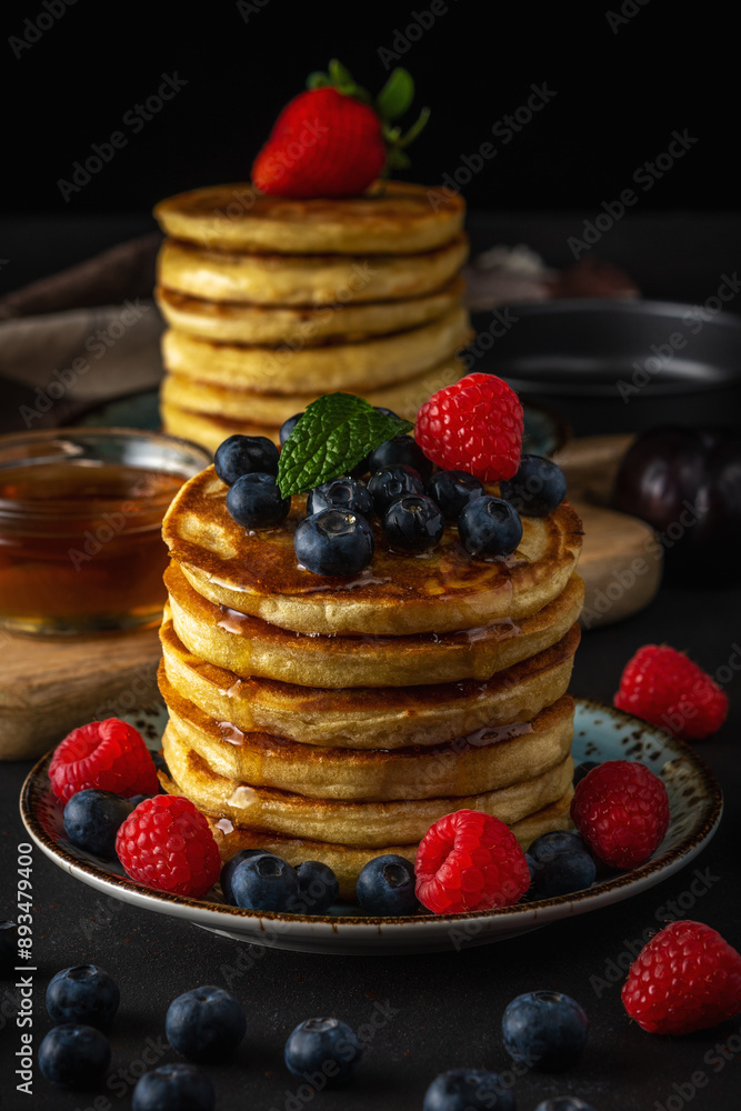 Delicious pancakes with fresh berries on dark background. Food concept. Delicious pancakes with fresh berries on dark background. Food concept.