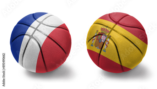 basketball balls with the national flags of spain and france on the white background. photo