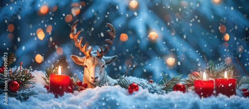 Yule Goat decoration with lit candles in snowy outdoor setting against a winter natural backdrop symbolizing Scandinavian and Northern European Yuletide and Christmas celebrations Copy space image ava