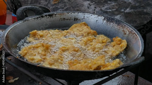 Jakarta, Indonesia-18 July,2024:Making process of Tempe Goreng or Tempe Mendoan. Indonesian traditional food made from tempeh covered in flour batter. photo