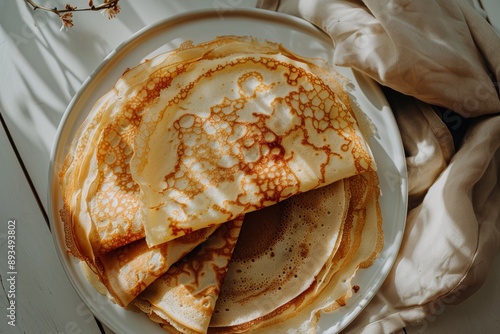Plate of crêpe crêpe pastry dessert with warm morning sunlight shining on it. Copy text space. Top flat lay view.