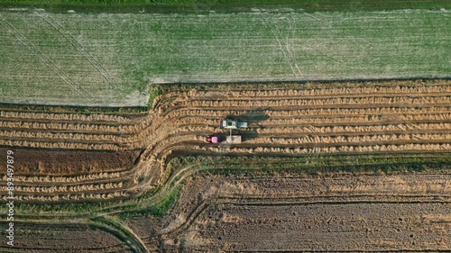 Żniwa - kombajn zbożowy wysypujący zborze na przyczepę - ujęcie z lotu ptaka photo