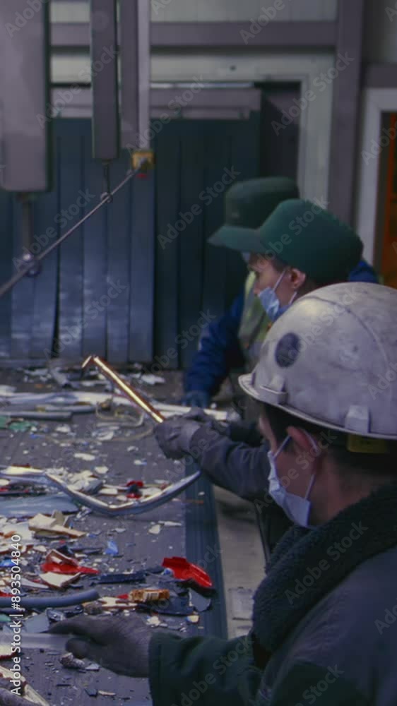 Man sorts garbage, electronics or plastic. Taking care of the environment. Waste recycling plant or garbage factory. Conveyor belt, trash moving along the line. Male have a eco-friendly work Man sorts garbage, electronics or plastic. Taking care of the environment. Waste recycling plant or garbage factory. Conveyor belt, trash moving along the line. Male have a eco-friendly work