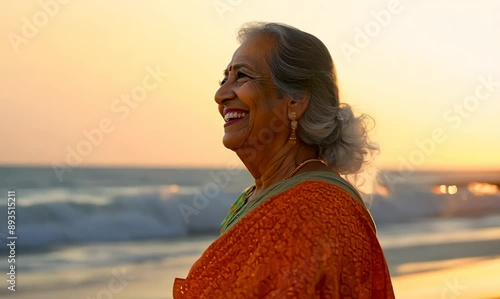 Portrait of smiling senior woman in saree on beach at sunset