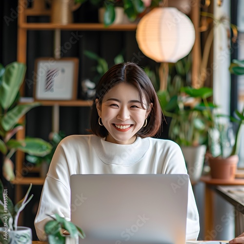
working Japanese woman with laptop, office, smile, wide shot, real photo